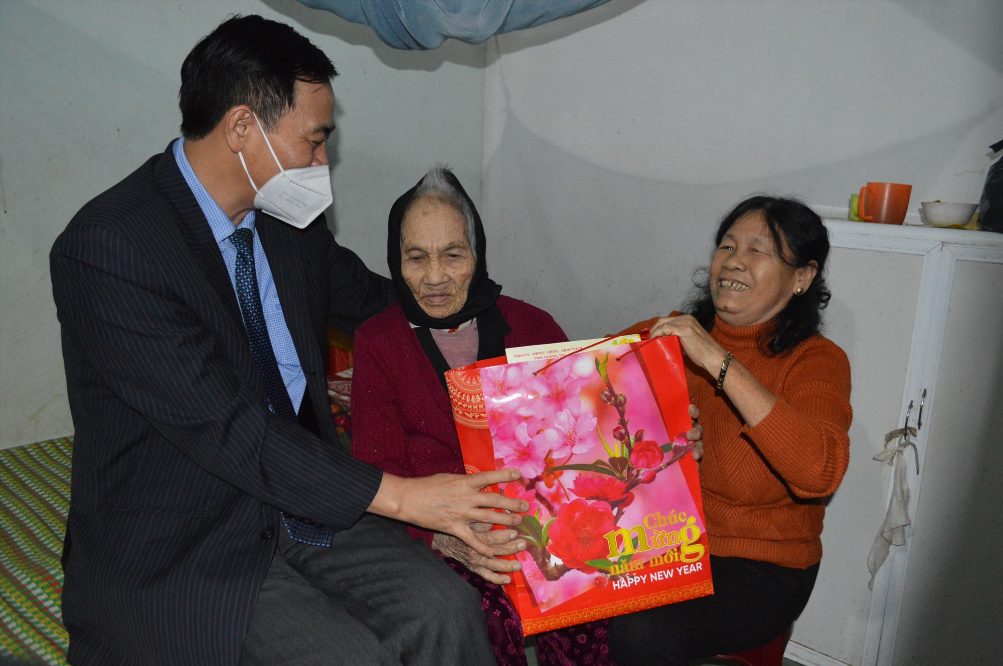 Phó Bí thư Thường trực Tỉnh ủy Nguyễn Đăng Quang chúc sức khỏe, tặng quà tết cho bà Tạ Thị Sang (102 tuổi), lão thành cách mạng ở Phường 1, thành phố Đông Hà - Ảnh: Đ.V