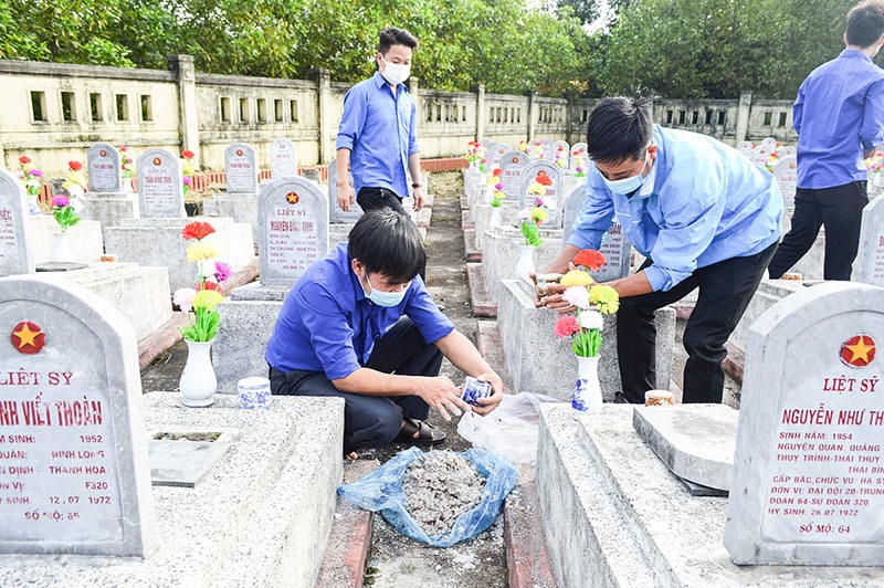 Đoàn viên thanh niên xã Hải Thượng, huyện Hải Lăng chăm sóc các phần mộ tại Nghĩa trang Liệt sĩ xã nhân dịp Tết Nguyên đán Nhâm Dần - 2022 - Ảnh: Đ.V