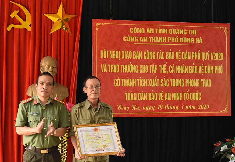 Ông Đào Ngọc Danh (phải) được tuyên dương tại hội nghị tổng kết công tác BVDP của Công an thành phố Đông Hà năm 2020 -Ảnh: SONG KHÁNH
