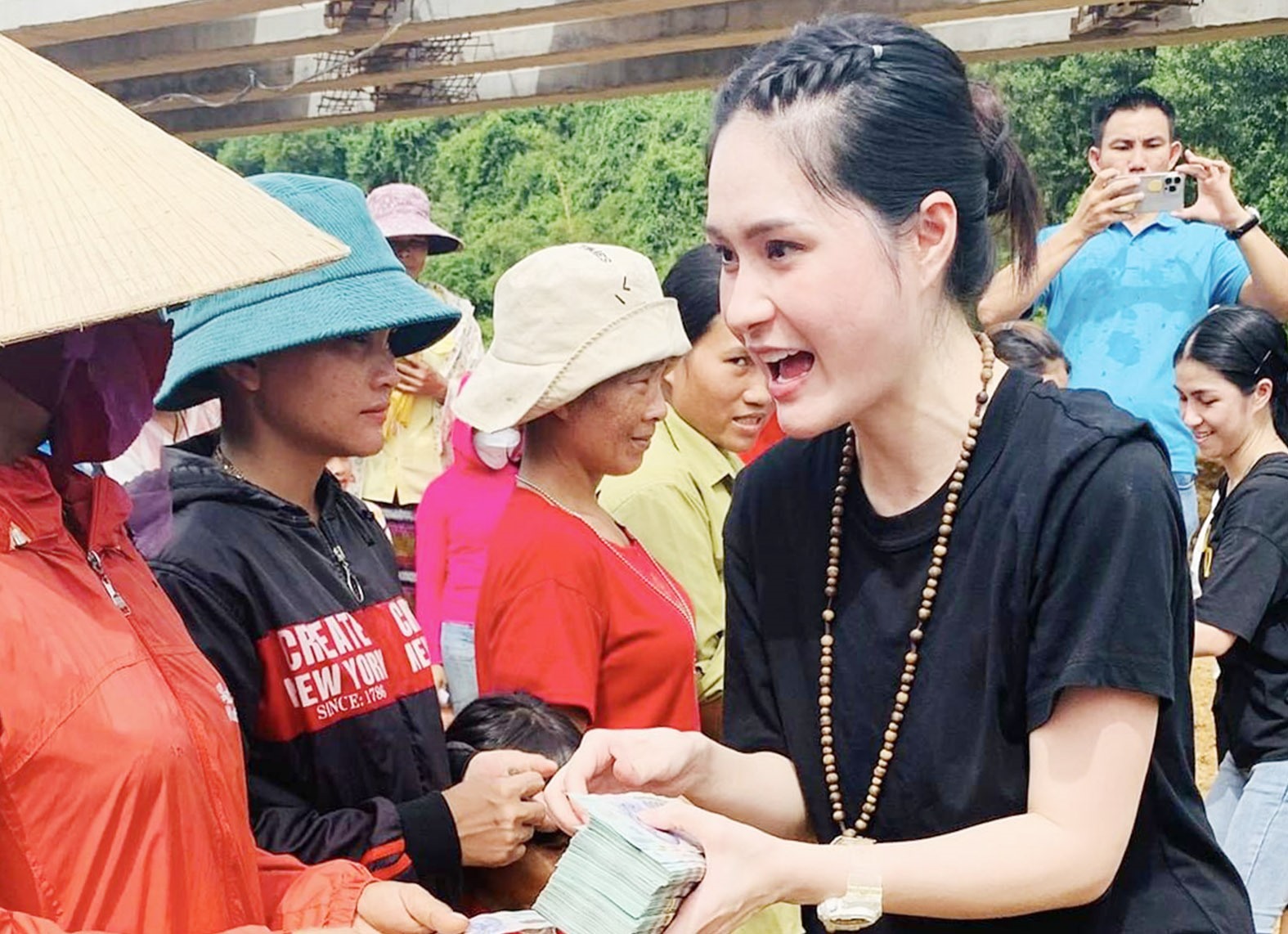Ca sĩ Đoàn Di Băng trao tặng tiền hỗ trợ cho người dân xã Vĩnh Ô - Ảnh: Tú Linh