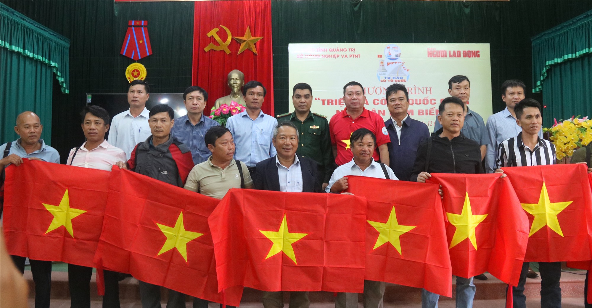 Tặng cờ Tổ quốc và túi cấp cứu chấn thương cho ngư dân thị trấn Cửa Việt - Ảnh: N.B