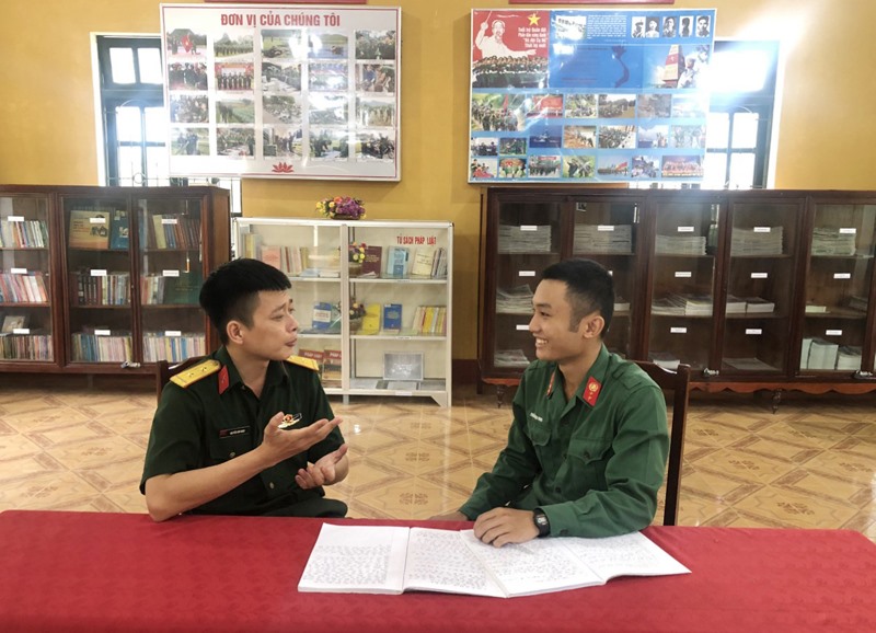 Chỉ huy đơn vị trao đổi phương pháp ôn kiến thức văn hóa với Binh nhất Trần Văn Ninh (bên phải) -Ảnh: M.H