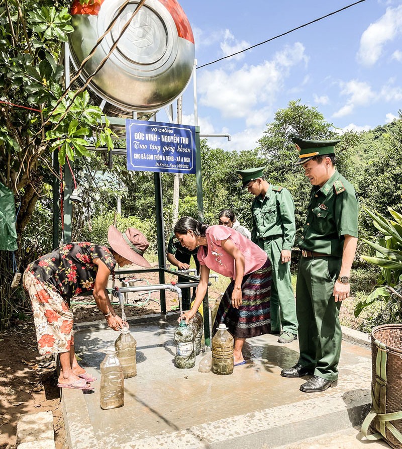 Cán bộ, chiến sĩ Đồn Biên phòng Cửa khẩu quốc tế La Lay hướng dẫn người dân thôn A Đeng, xã A Ngo, huyện Đakrông sử dụng nước giếng khoan - Ảnh: PV