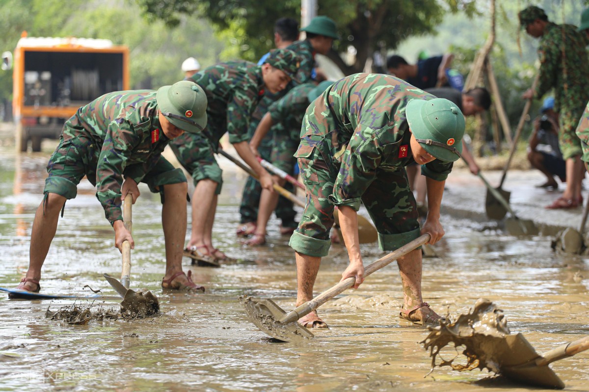 Các chiến sĩ Tiểu đoàn 1, Trung đoàn 6 thuộc Bộ chỉ huy Quân sự tỉnh Thừa Thiên Huế dùng xẻng dọn dẹp bùn non trên đường Bạch Đằng.