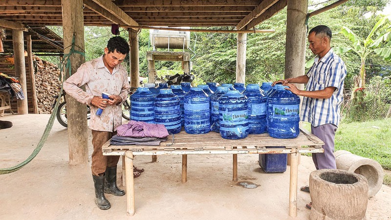 Người dân thôn Thuận1, xã Thuận chuẩn bị nước sạch đóng chai để đề phòng mưa lũ xảy ra dài ngày - Ảnh: L.A