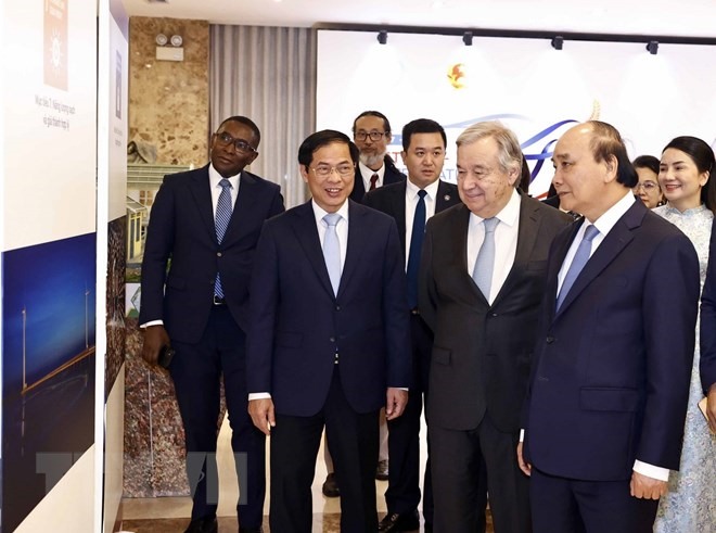 Chủ tịch nước Nguyễn Xuân Phúc, Tổng Thư ký Liên hợp quốc António Guterres và các đại biểu tham quan trưng bày ảnh tại lễ kỷ niệm. (Ảnh: TTXVN)
