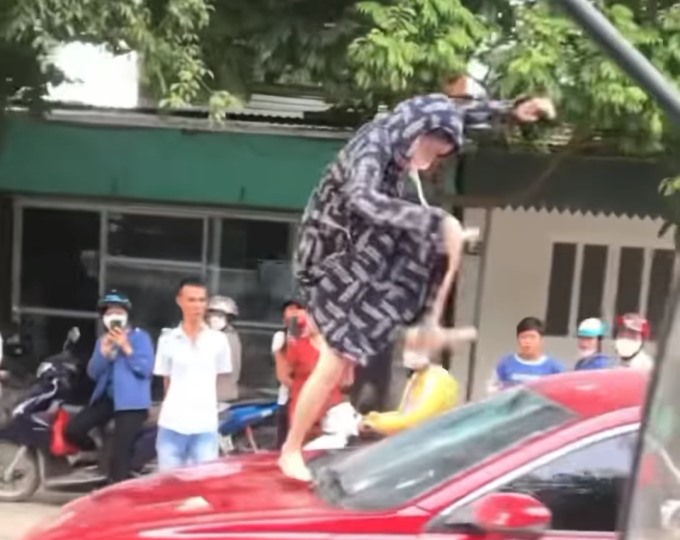 Hình ảnh người phụ nữ “tung cước” đạp vỡ kính xe ôtô trước sự chứng kiến của nhiều người. Ảnh cắt từ clip