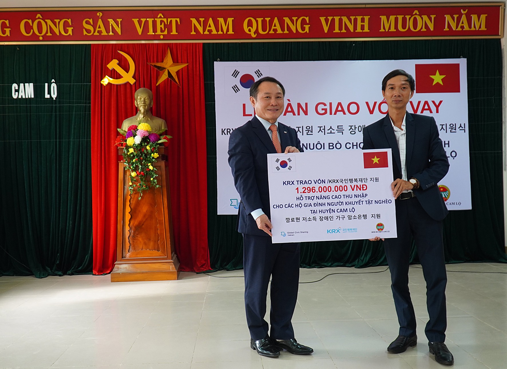 Đại diện Tổ chức GCS và Quỹ Hạnh phúc KRX trao bảng tượng trưng vốn vay cho các hộ nông dân huyện Cam Lộ-Ảnh: Anh Vũ