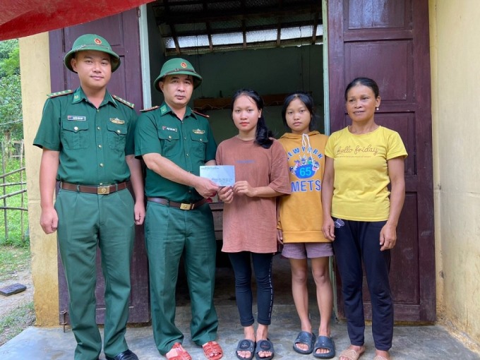 Bộ đội Biên phòng tỉnh Quảng Bình trao món quà chúc mừng nữ sinh Cao Thị Lệ Hằng (ở giữa) đậu đại học.