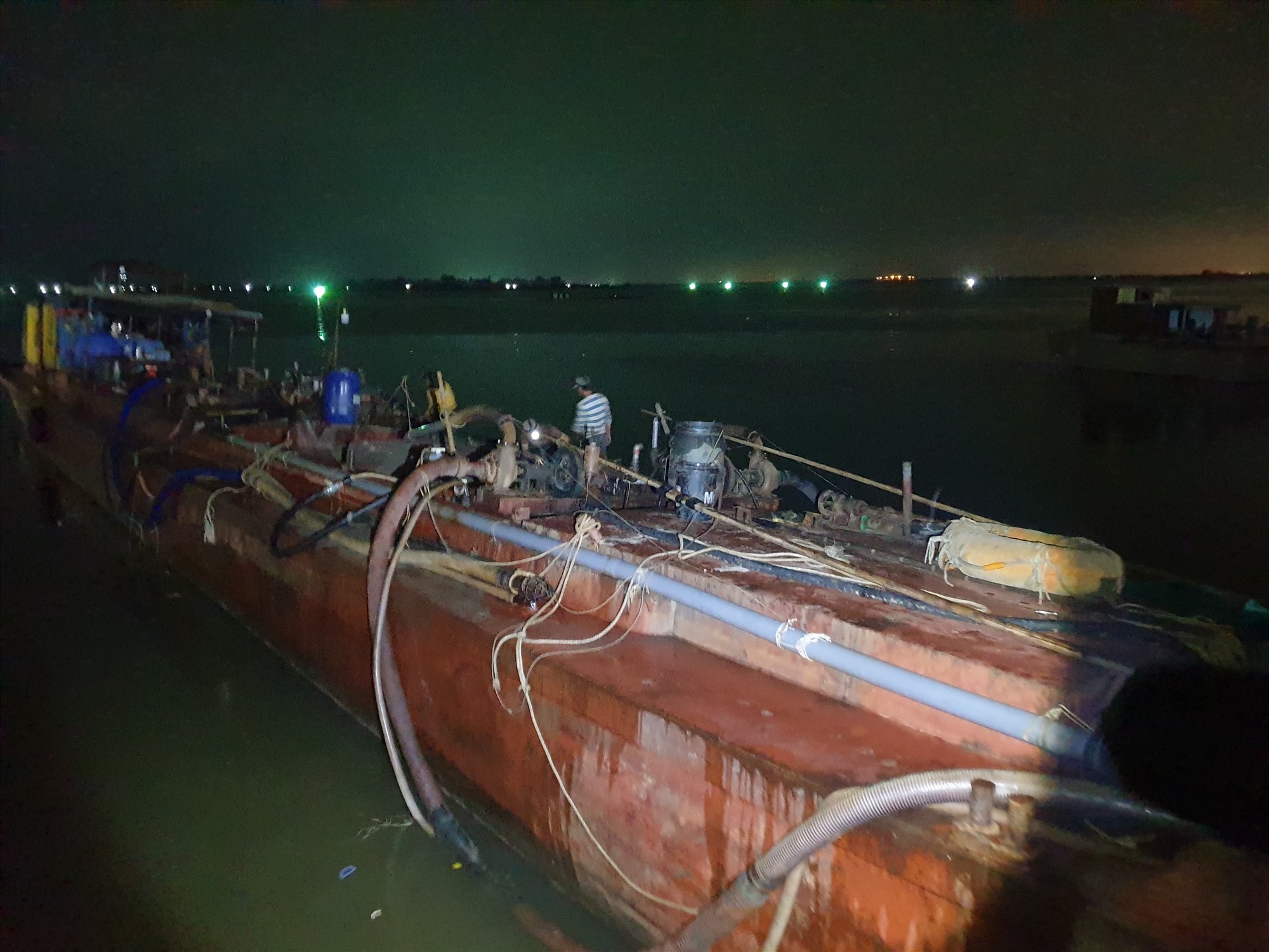 Một con tàu cập vào bến cá Cửa Việt rồi dùng máy và ống hút cỡ lớn để bơm cát lên khu vực bến cá - Ảnh: Trần Tuyền