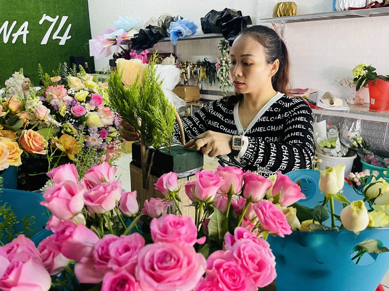 Chị Trần Huyền, chủ quán hoa Hana 74 tỉ mẫn trang trí những lẵng hoa tươi cho khách -Ảnh: T.T
