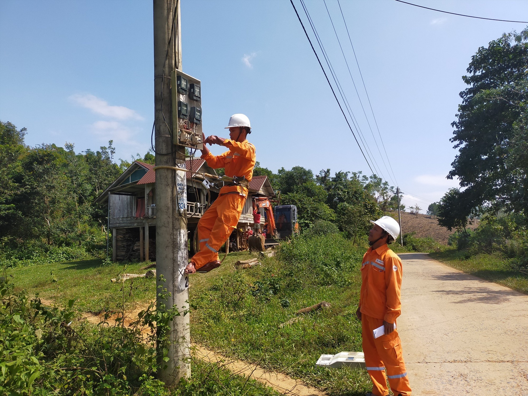 Công nhân Nguyễn Văn Quyền và đồng nghiệp trẻ thực hiện sửa chữa điện.  Ảnh: Lê Thế Minh