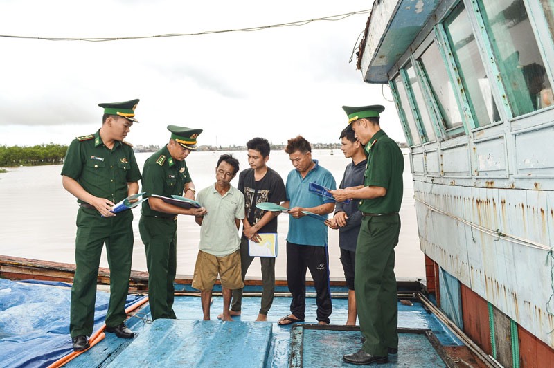 Lực lượng BĐBP Hải đội 2 tuyên truyền các quy định, chính sách pháp luật về khai thác hải sản trên biển cho ngư dân tại Cảng Cửa Việt - Ảnh: Đ.V