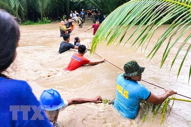Lực lượng cứu hộ Philippines sơ tán người dân khỏi khu vực ngập lụt do mưa lớn gây ra bởi bão Nalgae ở Kalamansig, Sultan Kudarat, ngày 28/10/2022. (Ảnh: AFP/TTXVN)