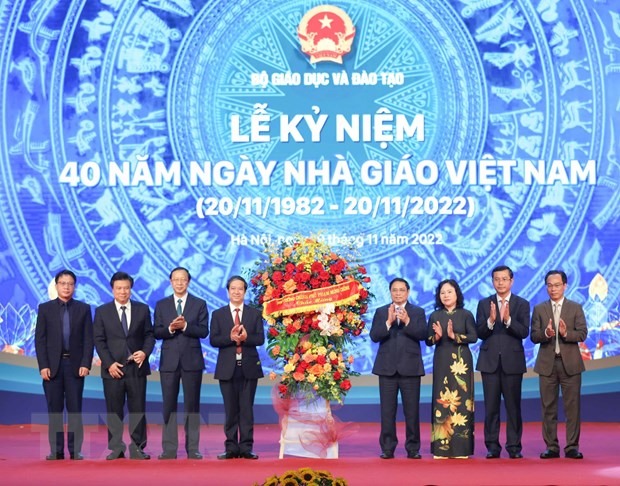 Thủ tướng Phạm Minh Chính tặng hoa chúc mừng ngành giáo dục. (Ảnh: Thanh Tùng/TTXVN)