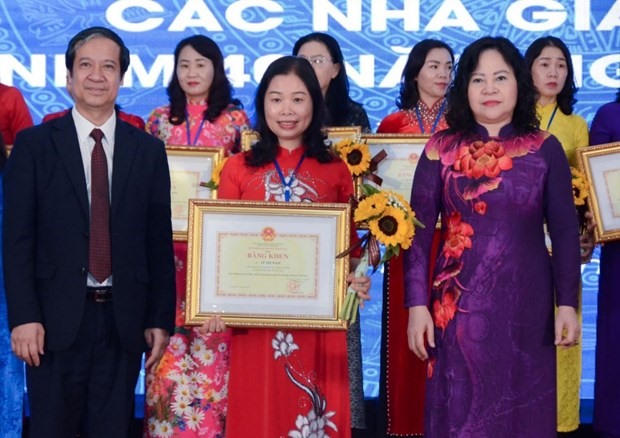 Bộ trưởng Bộ Giáo dục và Đào tạo Nguyễn Kim Sơn và Thứ trưởng Ngô Thị Minh tặng hoa và bằng khen cho các nhà giáo tiêu biểu nhân kỷ niệm 40 năm Ngày Nhà giáo Việt Nam. (Ảnh: Bộ GD-ĐT)