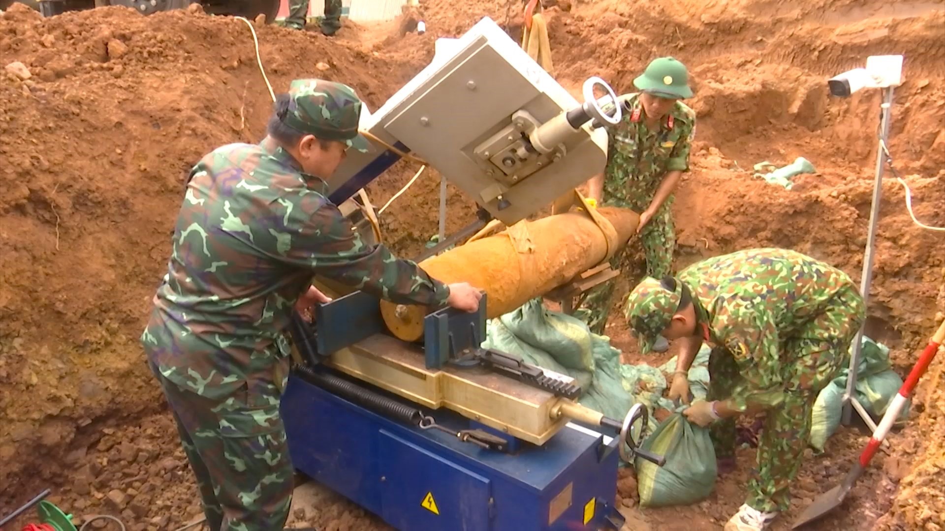 Lực lượng Công binh Bộ CHQS tỉnh tiến hành cắt cưa phần ngòi nổ bằng máy cắt điều khiển từ xa, sau đó hủy nổ - Ảnh: T.N