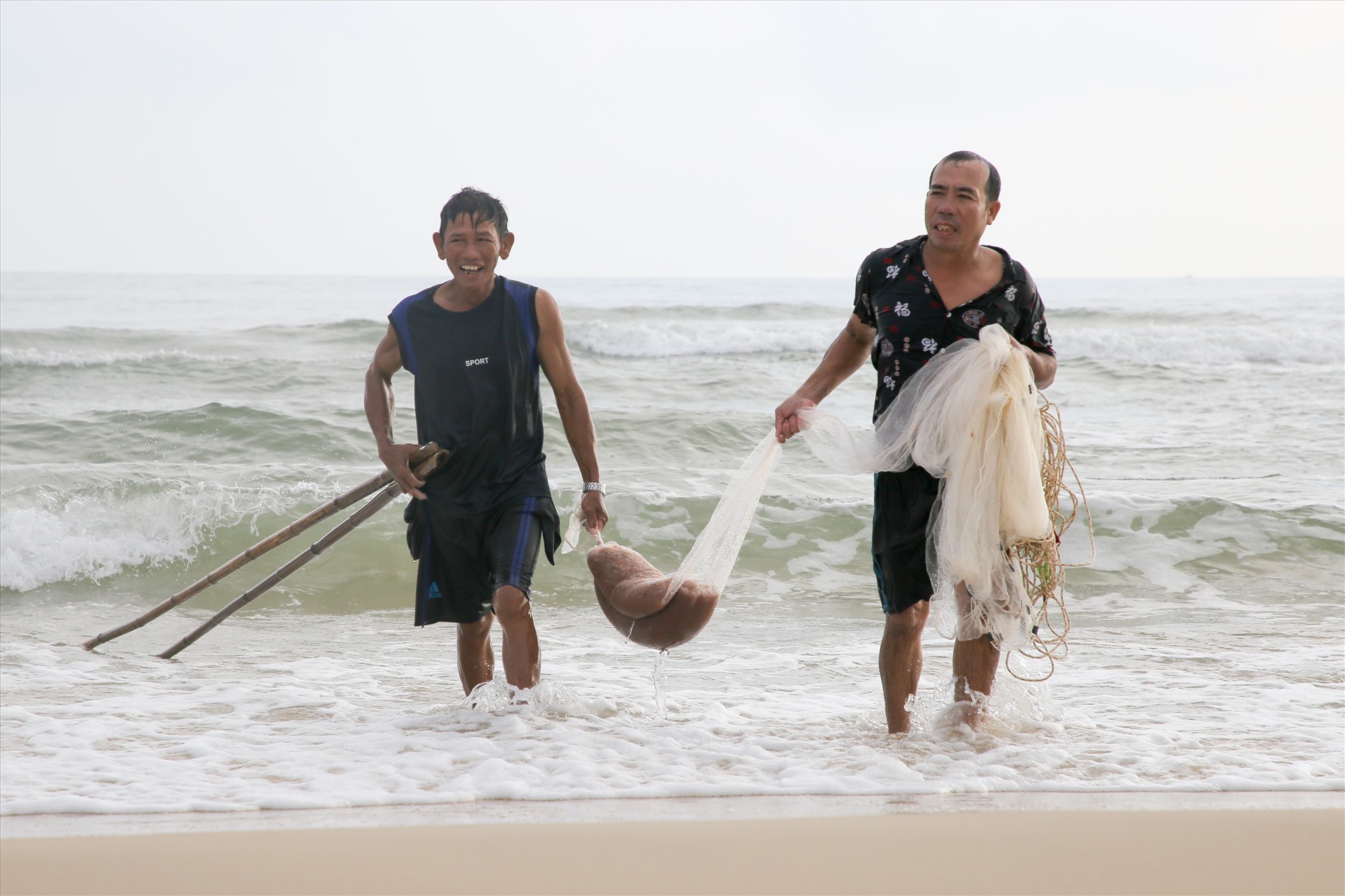 Ngư dân Nguyễn Văn Nguyên (bên phải), ở thôn Tân Hải, xã Gio Hải (huyện Gio Linh) phấn khởi lên bờ sau khi đã kéo được nhiều ruốc