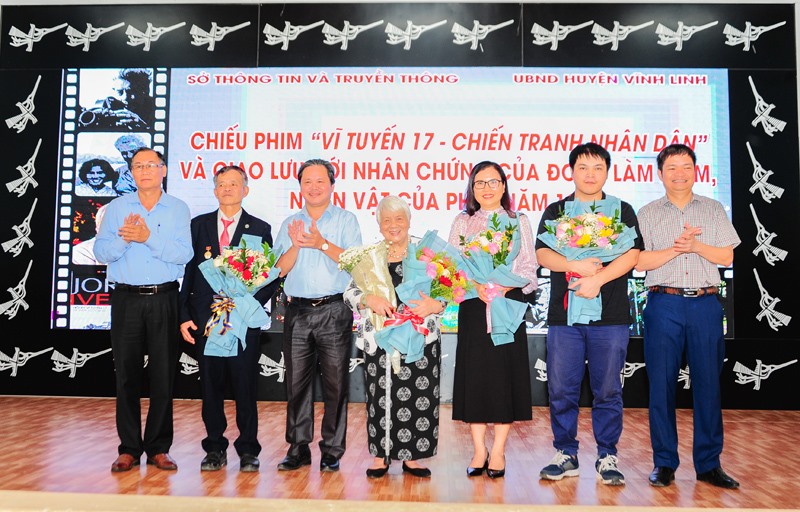Đại diện Sở Thông tin và Truyền thông phối hợp với UBND huyện Vĩnh Linh tặng hoa cho bà Nguyễn Thị Xuân Phượng và ông Phạm Công Đức - Ảnh: TRẦN TUYỀN