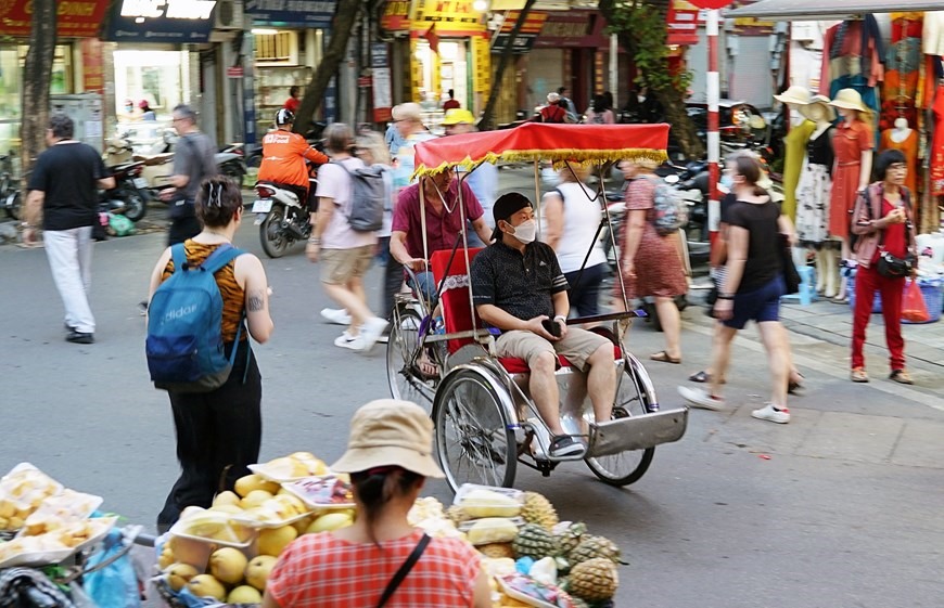 Du khách trải nghiệm tham quan đường phố Hà Nội bằng xích lô trên tuyến phố Hàng Bạc. (Ảnh: Khánh Hòa/TTXVN)