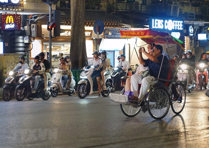 Du khách trải nghiệm du lịch bằng xích lô trên phố Tràng Tiền.(Ảnh: Khánh Hòa/TTXVN)