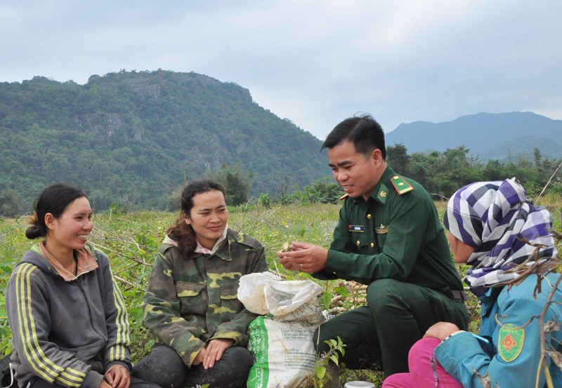 Thiếu tá Lê Văn Dùy vận động người dân chuyển đổi giống cây trồng, vật nuôi - Ảnh: Q.H