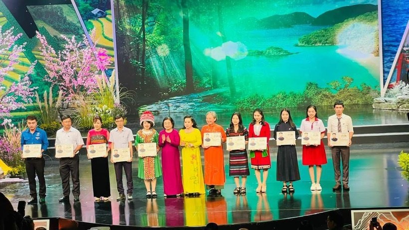 Bà Phan Vũ Diễm Hằng (áo dài màu cam), trưởng nhóm Ong chăm thay mặt nhóm nhận giải thưởng Vừ A Dính 2022.