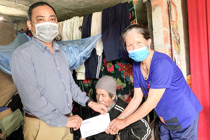 Đại diện PC Quảng Trị thăm, tặng quà bà Lê Thị Hồng ở thôn Cổ Lũy, xã Hải Ba, Hải Lăng có chồng bị khuyết tật nặng - Ảnh: T.N
