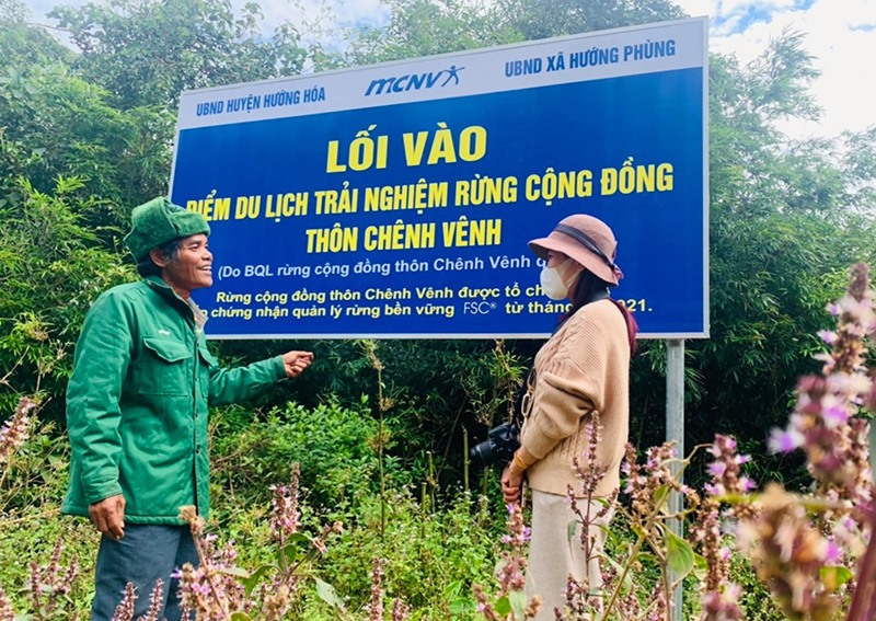 Ông Chiến (bên trái) giới thiệu với khách du lịch đến tham quan, trải nghiệm rừng cộng đồng thôn Chênh Vênh - Ảnh: M.L