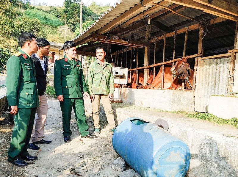 Cán bộ, nhân viên Đội sản xuất 6 chia sẻ kinh nghiệm nuôi bò vỗ béo cùng người dân thôn Mã Lai Pun - Ảnh: B.L