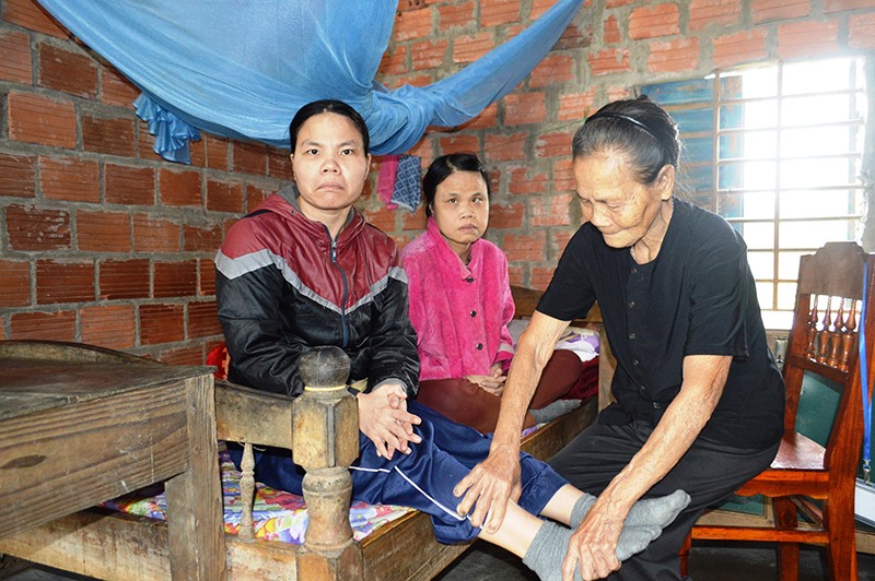 Bà Phan Thị Túy chăm sóc con gái bị bại liệt - Ảnh: ĐV