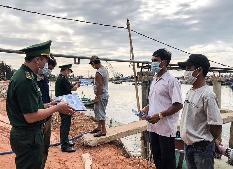 Cán bộ, chiến sĩ Đồn Biên phòng Cửa khẩu Cảng Cửa Việt tuyên truyền pháp luật cho ngư dân - Ảnh: N.B