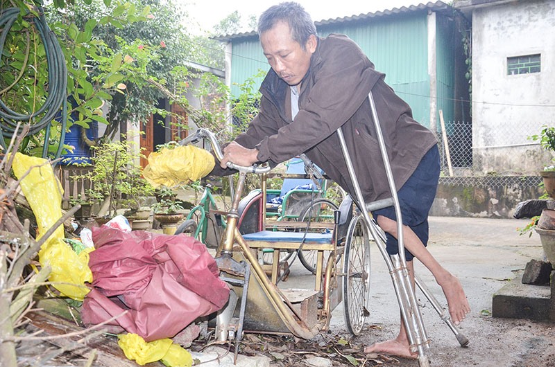 Anh Nguyễn Văn Thành đang sửa chữa lại chiếc xe lắc là phương tiện di chuyển hằng ngày của mình - Ảnh: L.M