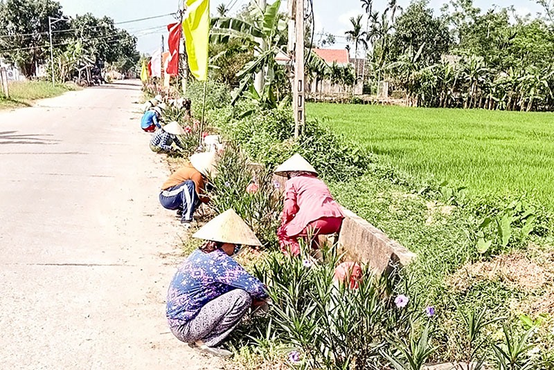Hội viên phụ nữ xã Triệu Long xây dựng đường hoa, góp phần làm xanh, sạch, đẹp đường nội thôn - Ảnh: N.T