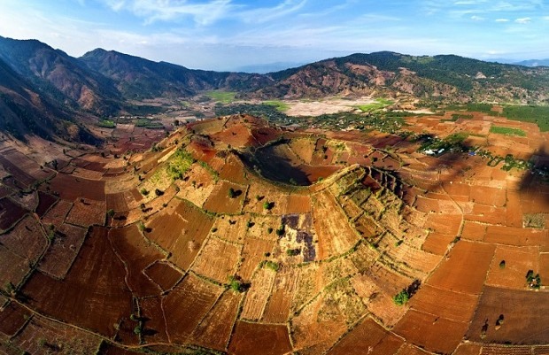 Từ trên cao nhìn xuống núi lửa Chư Đăng Ya tựa như một cái phễu khổng lồ với lòng chảo miệng núi mang sắc đỏ đất bazan màu mỡ. Ảnh: vietnambooking.com