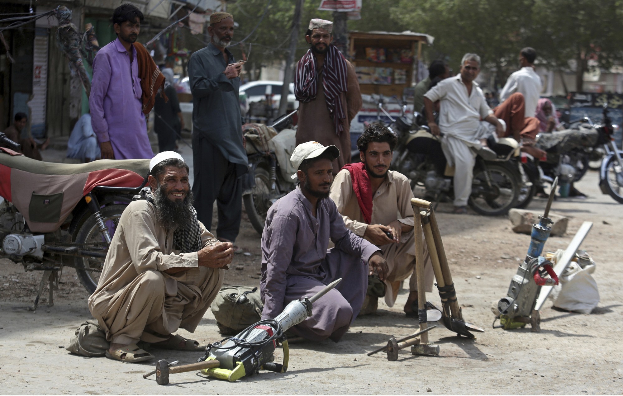 Những người lao động trong ngày của Pakistan ngồi bên cạnh những công cụ của họ khi họ chờ đợi việc làm vào Ngày tháng Năm, còn được gọi là Ngày Quốc tế Lao động, ở Karachi. Ảnh: AP