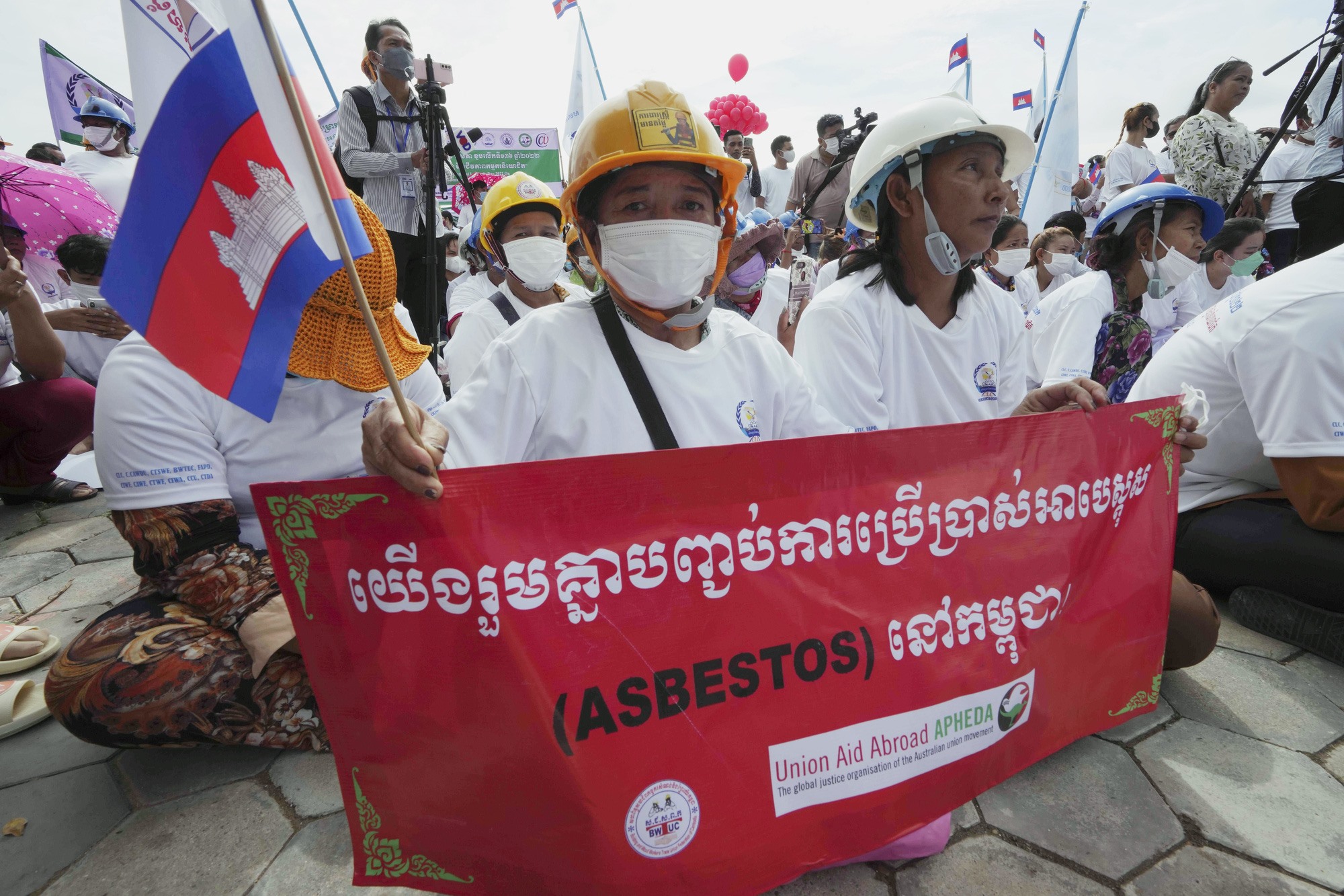 Công nhân Campuchia cầm biểu ngữ với khẩu hiệu 'Chúng ta cùng nhau chấm dứt việc sử dụng ASBESTOS ở Campuchia' khi họ tham gia vào một cuộc tụ họp để đánh dấu Ngày tháng Năm gần chùa Wat Phnom ở trung tâm Phnom Penh, Campuchia. Ảnh: AP