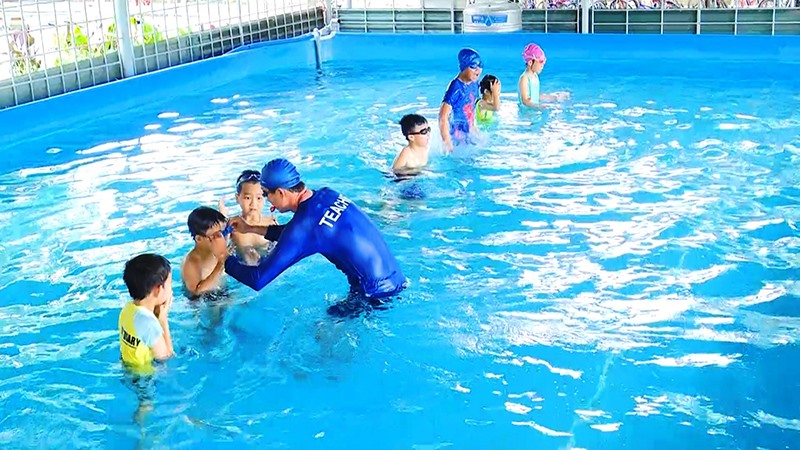 Giáo viên môn Giáo dục thể chất Trường Tiểu học Hàm Nghi, TP. Đông Hà dạy kỹ năng bơi lội cho các em học sinh - Ảnh: Đ.V