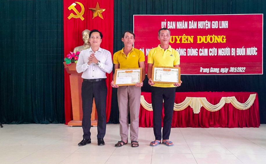 Phó Chủ tịch UBND huyện Gio Linh Dương Đức Hạnh tặng giấy khen cho anh Phan Thanh Tuấn và Phan Thanh Tú - Ảnh: Trần Tuyền