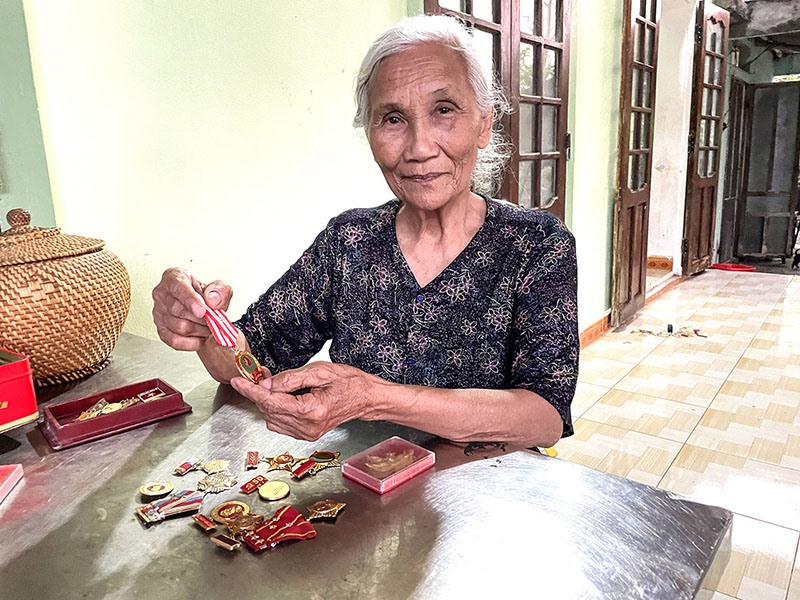 Bà Trần Thị Lành tự hào với những tấm huân chương được tặng trong quá trình tham gia giải phóng quê hương - Ảnh: Đ.T