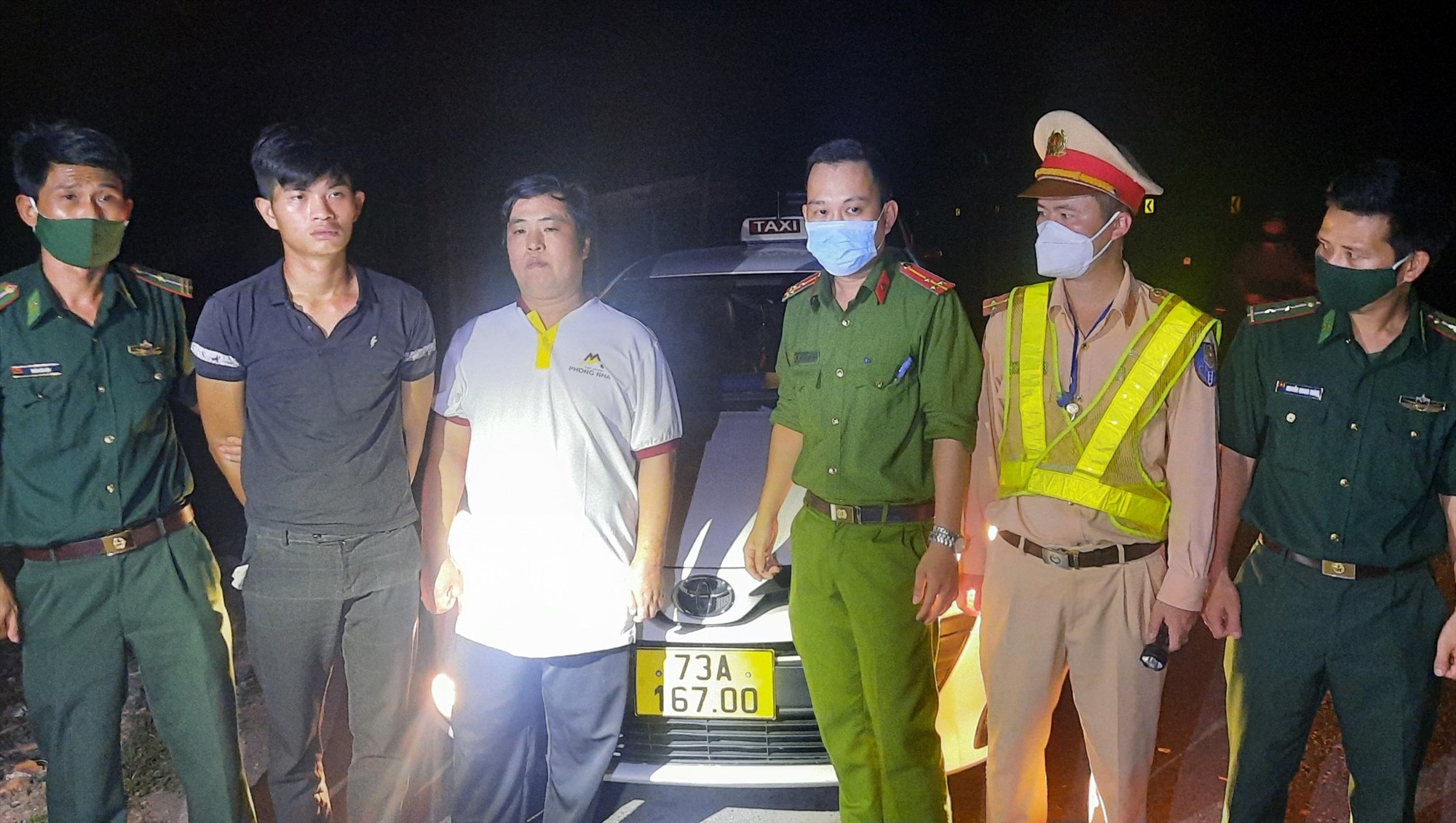 Đặng Quang Huy (thứ 2 từ trái sang) và tài xế Nguyễn Mạnh Hà (thứ 3 từ trái sang) bị các lực lượng bắt giữ – Ảnh: Mạnh Hùng