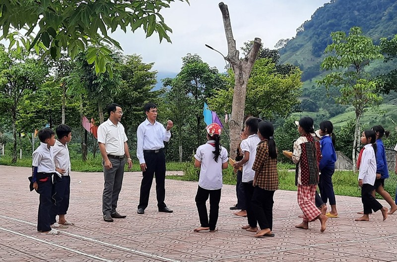 Anh Hồ Văn Niêu (thứ 3, bên trái) cùng Hiệu trưởng Trường TH &THCS A Ngo Hoàng Quang Cẩn trò chuyện với các em học sinh - Ảnh: L.N