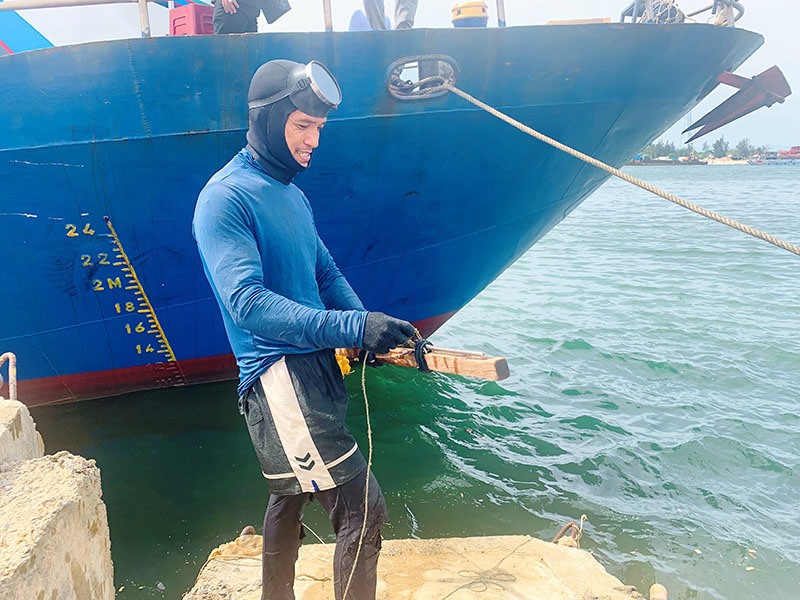 Anh Nguyễn Văn Xinh chuẩn bị lặn xuống biển để bắn cá - Ảnh: ĐV