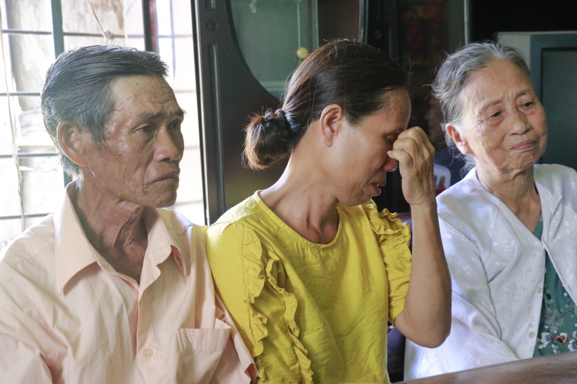 Gia đình chị Trần Thị Ngọc Ánh xúc động khi nhận được tiền hỗ trợ xây nhà. Ảnh: TRƯỜNG SƠN