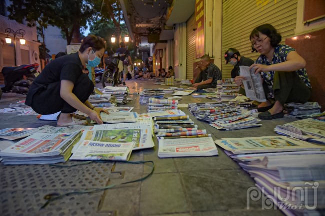 Những người bán báo giấy trên phố Đinh Tiên Hoàng, Hai Bà Trưng ( Hà Nội) lúc 5h sáng. Đây là nơi tập kết báo để giao đến các sạp bán lẻ tại Hà Nội và các tỉnh thành lân cận: Ảnh chụp 5 giờ sáng ngày 17/6.