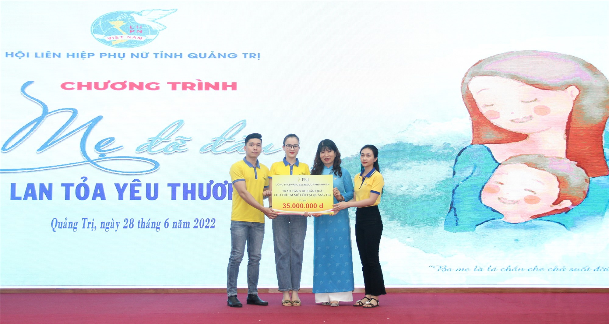 Đại diện Công ty Cổ phần Vàng bạc Đá quý Phú Nhuận (PNJ) trao biển tượng trưng tặng 70 suất quà cho trẻ em mồ côi, trị giá 35 triệu đồng -Ảnh: MĐ