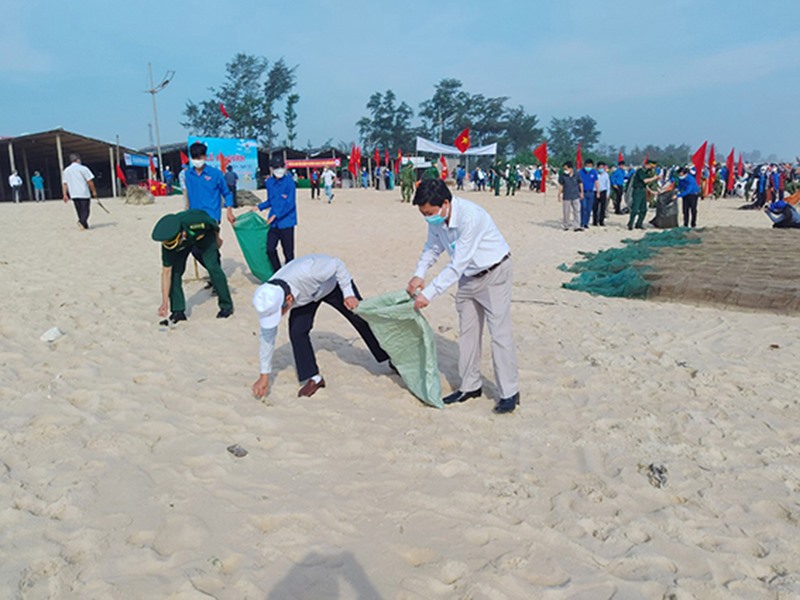 Cán bộ, viên chức, người lao động và đông đảo người dân tham gia thu gom rác thải dọc bãi biển trong lễ ra quân hành động bảo vệ môi trường - Ảnh: L.T