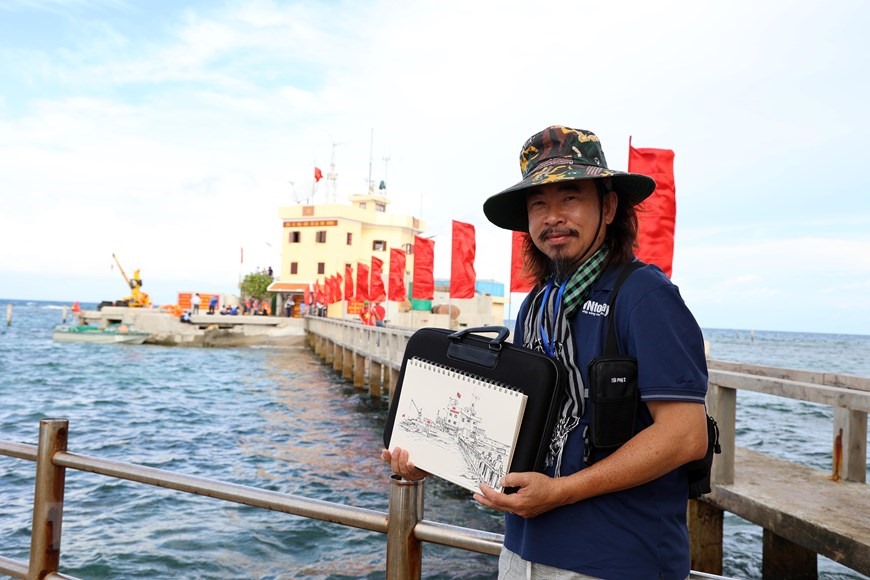 Anh Nguyễn Quang Trường (Etcetera Nguyễn), kiều bào Mỹ, ký họa các đảo trong chuyến thăm Trường Sa và Nhà dàn DK1. (Ảnh: Diệp Trương/TTXVN)