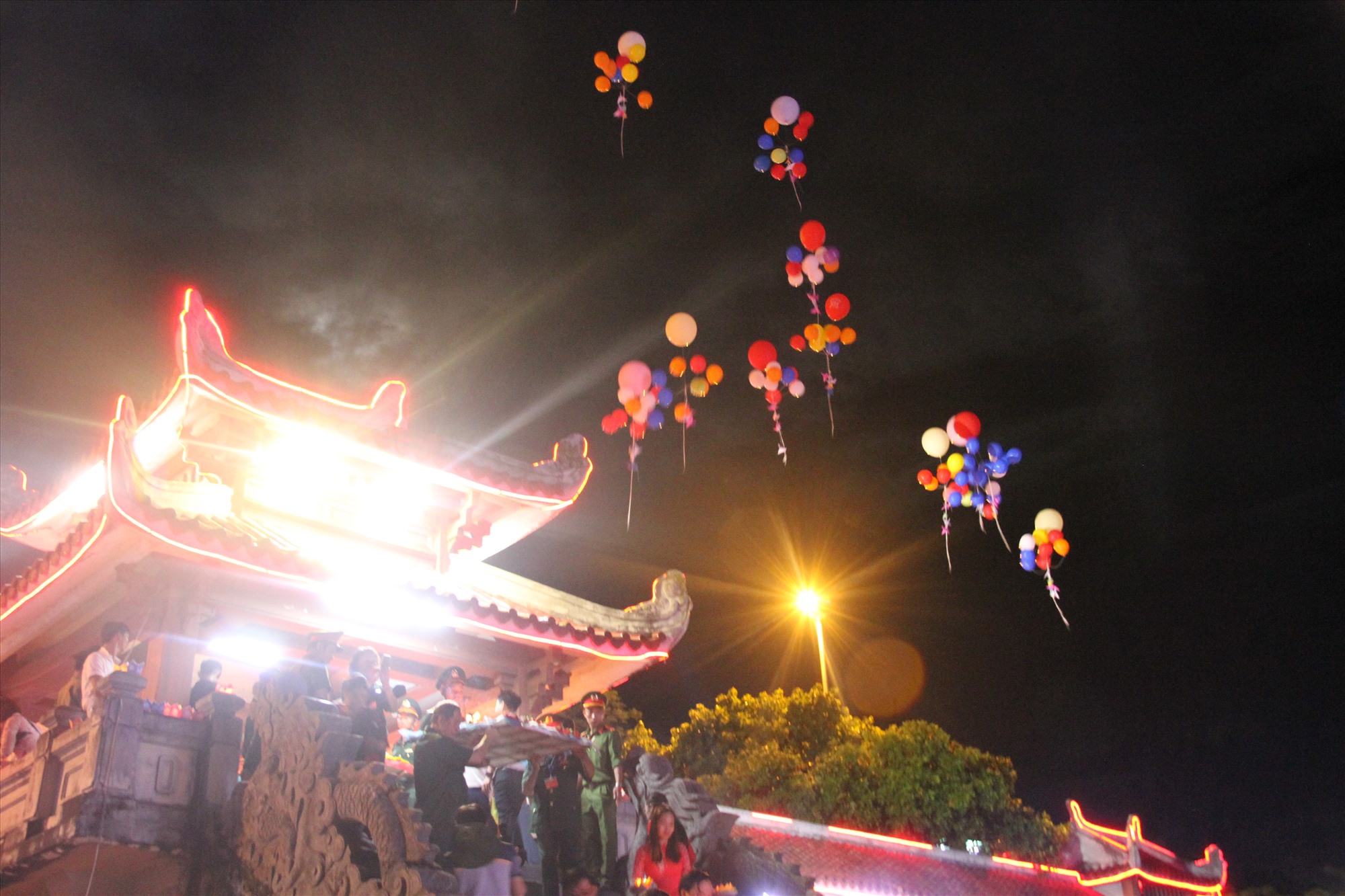 Nhiều chùm bóng bay gắn thêm những con chim hạc bằng giấy mang biểu tượng an lành và hòa bình được thả lên lên bầu trời thị xã Quảng Trị - Ảnh: MĐ
