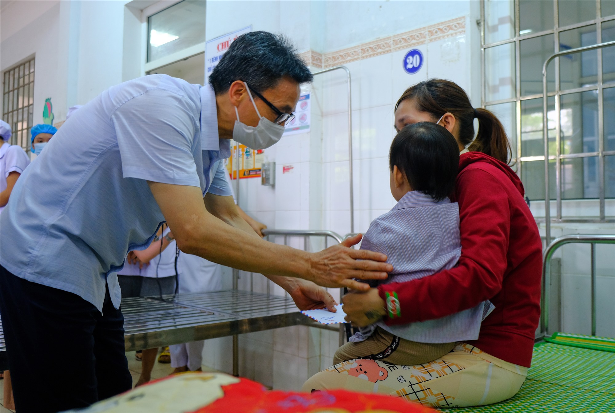 Phó Thủ tướng Chính phủ Vũ Đức Đam thăm hỏi, động viên, tặng quà cho bệnh nhân đang điều trị tại Trung tâm Y tế huyện Hải Lăng - Ảnh: Trần Tuyền